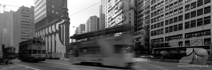 HONG KONG TRAMS RUSHING BY IN BLACK AND WHITE