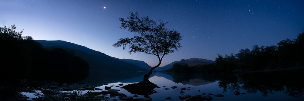 Snowdonia national park lake at night with the moon and stars