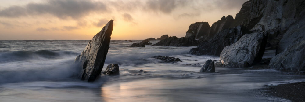 Panorama of the dramatic Devon coastline at sunset