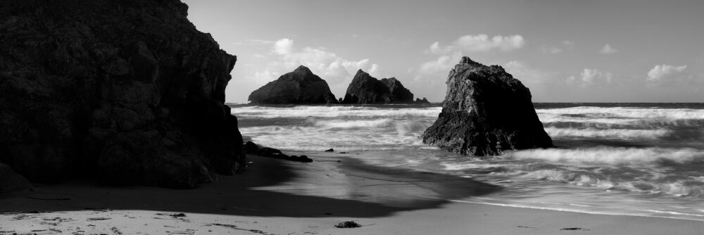 Panorama of Holywell bay and gull rock in b&w