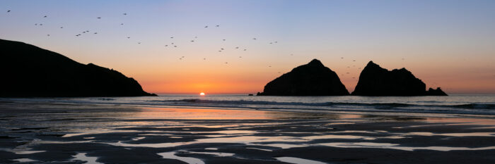 Panorama of Holywell bay and gull rock at sunset along the south west coast path in Cornwall