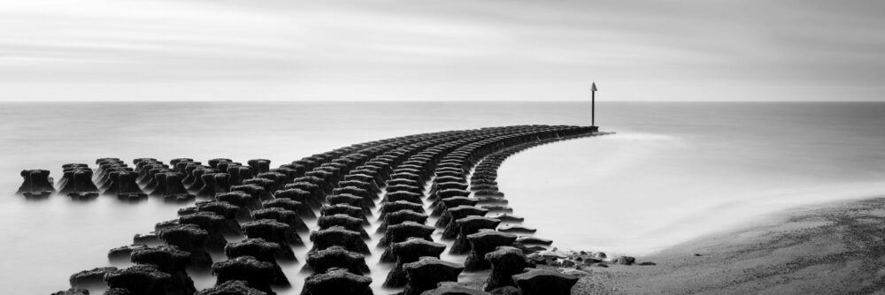 Panorama of Cubbolds Point sea defences in Felixstowe Suffolk black and white