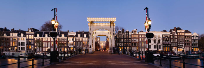 Panorama of the Magere Brug in Amsterdam lit up at sunset