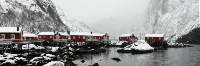Panorama of the Nusfjord red cabins covered in snow in winter in the Lofoten Islands