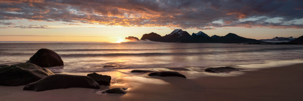 Panorama of the midnight sun at Storsandnes beach at sunrise in the Lofoten Islands