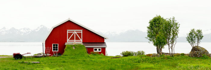 Panorama of a red barn on the Coast of Langøya Island in Vesterålen with the Lofoten Mountains behind