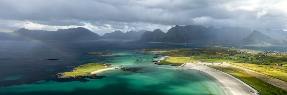 Panorama of Sandbotnen beach and bay with a rainbow taken from Røren mountain in the Lofoten Islands