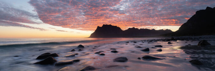 Panorama of Uttakleiv beach with red skies during a sunrise in the Lofoten Islands in Norway
