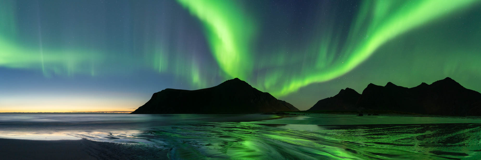 Panorama of the northern lights on Skagsanden beach in Flakstadøya int eh Lofoten Islands in the arctic circle