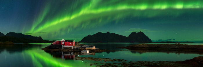 Panorama of a Norwegian Rorbu under the Northern Lights in the Lofoten Islands