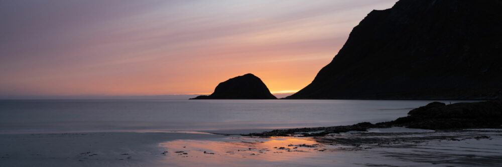 Taa Island and Haukland beach at sunset in the Lofoten Islands