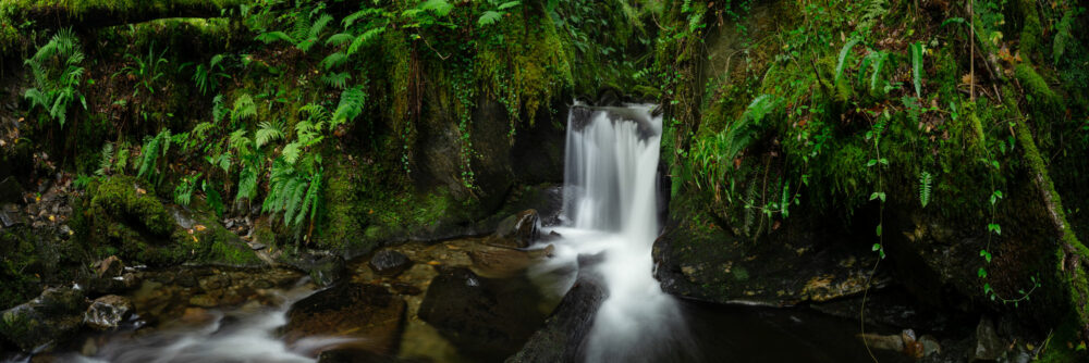 Panorama of a hidden waterfall in the Fairy Glen Creran in Scotland