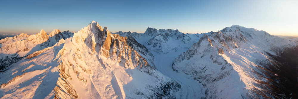 Aerial Panorama of the Aiguilles de Chamonix on the Mont Blanc Massif and mer de Glace Glacier covered in snow in winter in the French Alps